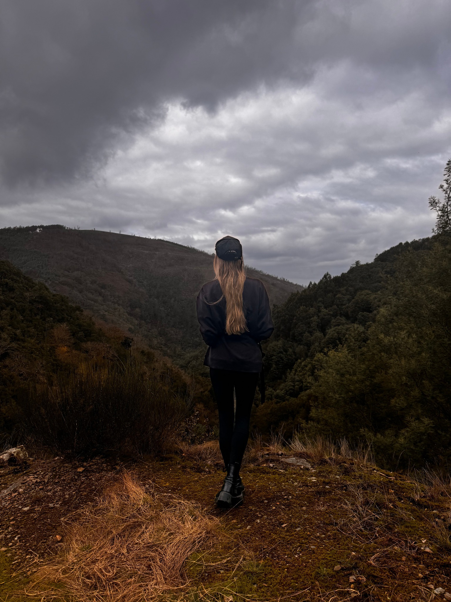 Isabel Saldanha de costas, diante de uma paisagem montanhosa