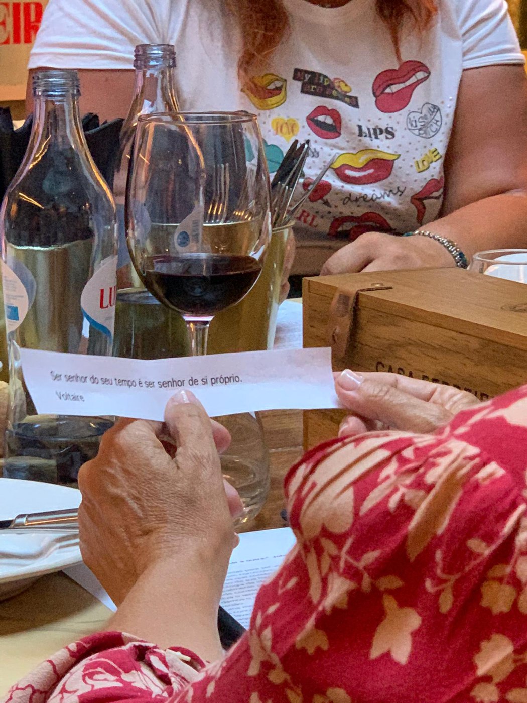 Detalhe de m&atilde;os a brindar com copos de vinho tinto